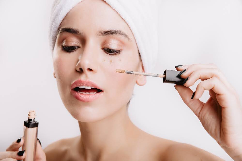 girl applying concealer